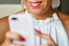 Mujer sonriente irreconocible que usa smartphone fotos de archivo libres de regalías Mujer sonriente irreconocible que usa smartphone fotos de archivo libres de regalías