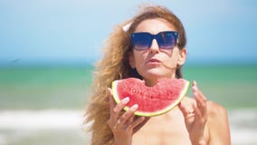 Mujer sonriente que come la sandía en la playa Mujer que come la fruta sabrosa del verano Tiempo de verano feliz metrajes Mujer sonriente que come la sandía en la playa Mujer que come la fruta sabrosa del verano Tiempo de verano feliz metrajes