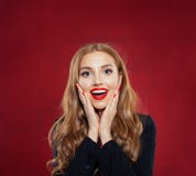 Mujer sorprendida con la boca abierta en fondo rojo Muchacha feliz que se divierte Emociones positivas foto de archivo Mujer sorprendida con la boca abierta en fondo rojo Muchacha feliz que se divierte Emociones positivas foto de archivo