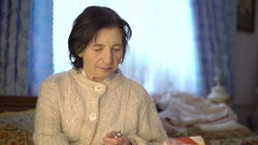 Mujer ucraniana mayor jubilada que usa la medicina y la lectura almacen de video Mujer ucraniana mayor jubilada que usa la medicina y la lectura almacen de video