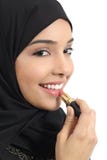 Mujer árabe de los emiratos del saudí que pinta sus labios con un lápiz labial fotografía de archivo libre de regalías Mujer árabe de los emiratos del saudí que pinta sus labios con un lápiz labial fotografía de archivo libre de regalías