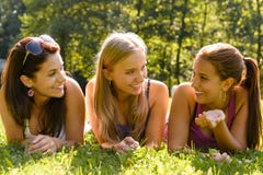 Mujeres adolescentes que hablan y que se relajan en parque Fotos de archivo libres de regalías Mujeres adolescentes que hablan y que se relajan en parque Fotos de archivo libres de regalías