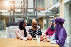 Mujeres jovenes musulmanes de la pertenencia ?tnica diversa que hablan del nuevo libro del autor famoso fotos de archivo libres de regalías Mujeres jovenes musulmanes de la pertenencia ?tnica diversa que hablan del nuevo libro del autor famoso fotos de archivo libres de regalías