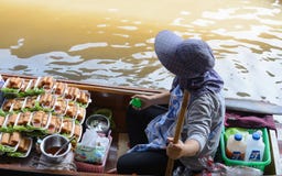 Mujeres locales del vendedor con un barco en el mercado flotante Damnoen Saduak cerca de Bangkok, Bangko de Tailandia foto de archivo libre de regalías Mujeres locales del vendedor con un barco en el mercado flotante Damnoen Saduak cerca de Bangkok, Bangko de Tailandia foto de archivo libre de regalías