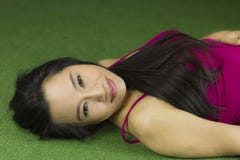 Mujeres que mienten en la hierba verde, una mujer tailandesa hermosa y so?adora colocando en la hierba verde, relaj?ndose mientra foto de archivo libre de regalías Mujeres que mienten en la hierba verde, una mujer tailandesa hermosa y so?adora colocando en la hierba verde, relaj?ndose mientra foto de archivo libre de regalías