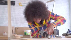 Mulher afro-americano nova feliz com o penteado do Afro que faz reparos, carpintaria video estoque Mulher afro-americano nova feliz com o penteado do Afro que faz reparos, carpintaria video estoque