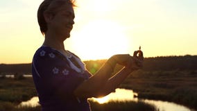 A mulher animador gerencie um girador em um banco do lago no verão no slo-mo filme A mulher animador gerencie um girador em um banco do lago no verão no slo-mo filme