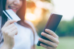 Mulher asiática nova bonita que usa seu smartphone para comprar em linha imagem de stock royalty free Mulher asiática nova bonita que usa seu smartphone para comprar em linha imagem de stock royalty free