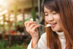 Mulher asiática nova bonito feliz atrativa que senta e que come a sobremesa no café do ar livre Alimento, alimentos sem valor nut Fotos de Stock Royalty Free Mulher asiática nova bonito feliz atrativa que senta e que come a sobremesa no café do ar livre Alimento, alimentos sem valor nut Fotos de Stock Royalty Free