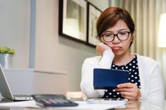 Mulher asiática nova preocupada que calcula suas despesas mensais fotografia de stock Mulher asiática nova preocupada que calcula suas despesas mensais fotografia de stock