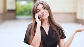 A mulher atrativa disparada zorra anda na rua e no smartphone de fala vídeos de arquivo A mulher atrativa disparada zorra anda na rua e no smartphone de fala vídeos de arquivo