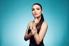 Mulher bonita com cabelo escuro muito longo em um fundo azul T fotografia de stock Mulher bonita com cabelo escuro muito longo em um fundo azul T fotografia de stock