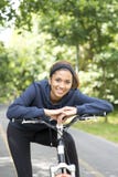 Mulher bonita de sorriso que exercita com a bicicleta, exterior imagem de stock royalty free Mulher bonita de sorriso que exercita com a bicicleta, exterior imagem de stock royalty free