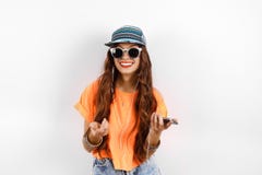 A mulher bonita do moderno novo nos óculos de sol que vestem no tampão e a música de escuta do t-shirt alaranjado nos fones de ou imagens de stock A mulher bonita do moderno novo nos óculos de sol que vestem no tampão e a música de escuta do t-shirt alaranjado nos fones de ou imagens de stock