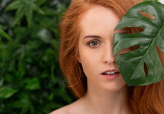 Mulher bonita do ruivo com pele perfeita nas folhas tropicais imagens de stock Mulher bonita do ruivo com pele perfeita nas folhas tropicais imagens de stock