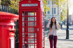 A mulher bonita do viajante de Londres está ao lado de uma cabine de telefone vermelha imagem de stock A mulher bonita do viajante de Londres está ao lado de uma cabine de telefone vermelha imagem de stock