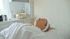 Mulher bonita no roupão que encontra-se e que espera o procedimento facial do cuidado no salão de beleza dos termas fotos de stock Mulher bonita no roupão que encontra-se e que espera o procedimento facial do cuidado no salão de beleza dos termas fotos de stock