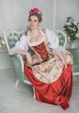 Mulher bonita no vestido medieval antiquado no sofá fotografia de stock Mulher bonita no vestido medieval antiquado no sofá fotografia de stock