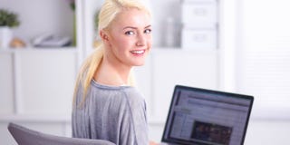 Mulher bonita nova que usa um laptop em casa imagem de stock royalty free Mulher bonita nova que usa um laptop em casa imagem de stock royalty free