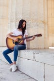 Mulher bonita que joga a guitarra acústica Foto de Stock Royalty Free Mulher bonita que joga a guitarra acústica Foto de Stock Royalty Free