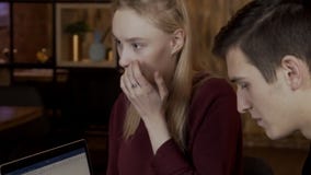Mulher bonita que sorri entre jovens perto de um portátil video estoque Mulher bonita que sorri entre jovens perto de um portátil video estoque