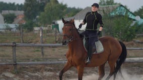 Há uma mulher montando um cavalo pulando sobre um obstáculo