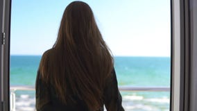 Mulher com as portas longas do balcão da abertura do cabelo e vista para fora no mar Apreciando a opinião do mar fora Tiro Slowmo filme Mulher com as portas longas do balcão da abertura do cabelo e vista para fora no mar Apreciando a opinião do mar fora Tiro Slowmo filme