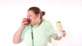 Mulher corpulento que esforça-se para comer saudável video estoque Mulher corpulento que esforça-se para comer saudável video estoque