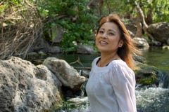 Mulher de Latina com posi??o s?ria da express?o na m?scara com cabelo de incandesc?ncia em um c?rrego com as cachoeiras no fundo fotografia de stock Mulher de Latina com posi??o s?ria da express?o na m?scara com cabelo de incandesc?ncia em um c?rrego com as cachoeiras no fundo fotografia de stock