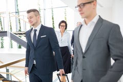 Mulher de neg?cios que anda com os colegas no escrit?rio foto de stock Mulher de neg?cios que anda com os colegas no escrit?rio foto de stock