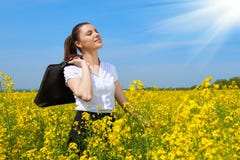 Mulher de negócio com a pasta que relaxa no sol inferior exterior do campo de flor Moça no campo amarelo da colza La bonito da mo Foto de Stock Mulher de negócio com a pasta que relaxa no sol inferior exterior do campo de flor Moça no campo amarelo da colza La bonito da mo Foto de Stock