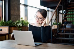 A mulher de negócio focalizada senta-se no funcionamento do café no portátil, no funcionamento fêmea sério concentrado com comput fotografia de stock royalty free A mulher de negócio focalizada senta-se no funcionamento do café no portátil, no funcionamento fêmea sério concentrado com comput fotografia de stock royalty free