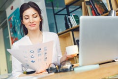 A mulher de negócio grávida que trabalha na leitura de assento da maternidade do escritório documenta o close-up foto de stock A mulher de negócio grávida que trabalha na leitura de assento da maternidade do escritório documenta o close-up foto de stock