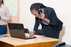 Mulher de negócio nova no telefone que toma notas fotos de stock Mulher de negócio nova no telefone que toma notas fotos de stock