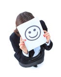 mulher de negócio nova que esconde atrás de uma face do smiley fotos de stock mulher de negócio nova que esconde atrás de uma face do smiley fotos de stock