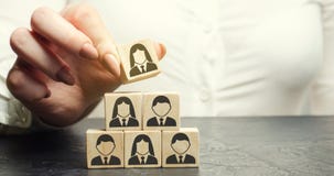 A mulher de negócio põe um cubo de madeira com a imagem dos trabalhadores Conceito misturado do pessoal Gestão do pessoal em uma imagem de stock A mulher de negócio põe um cubo de madeira com a imagem dos trabalhadores Conceito misturado do pessoal Gestão do pessoal em uma imagem de stock