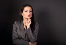 Mulher de negócio séria bonita no terno cinzento que pensa em g escuro Fotos de Stock Royalty Free Mulher de negócio séria bonita no terno cinzento que pensa em g escuro Fotos de Stock Royalty Free