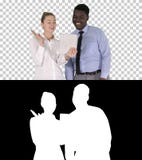 Mulher de negócios caucasiano nova e seu colega africano que fazem a chamada video com tabuleta, Alpha Channel fotografia de stock Mulher de negócios caucasiano nova e seu colega africano que fazem a chamada video com tabuleta, Alpha Channel fotografia de stock