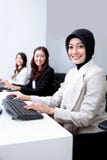 Mulher de negócios que sorri ao trabalhar no escritório foto de stock Mulher de negócios que sorri ao trabalhar no escritório foto de stock