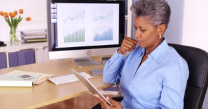 Mulher de negócios superior executiva que trabalha na tabuleta na mesa Imagem de Stock Royalty Free Mulher de negócios superior executiva que trabalha na tabuleta na mesa Imagem de Stock Royalty Free