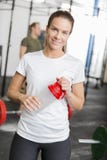 Mulher de sorriso no gym da aptidão que toma uma ruptura fotos de stock Mulher de sorriso no gym da aptidão que toma uma ruptura fotos de stock