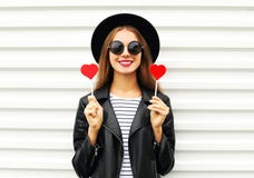 A mulher de sorriso nova consideravelmente doce da forma com bordos vermelhos guarda o casaco de cabedal vestindo do chapéu negro Imagens de Stock Royalty Free A mulher de sorriso nova consideravelmente doce da forma com bordos vermelhos guarda o casaco de cabedal vestindo do chapéu negro Imagens de Stock Royalty Free