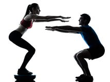 Mulher do homem do ônibus que exercita ocupas no bosu imagens de stock Mulher do homem do ônibus que exercita ocupas no bosu imagens de stock