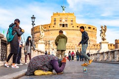 Mulher do mendigo que pede a esmola em seus joelhos em Ponte Sant ‘Angelo, ponte de Hadrian completamente de povos de passeio com fotos de stock royalty free Mulher do mendigo que pede a esmola em seus joelhos em Ponte Sant ‘Angelo, ponte de Hadrian completamente de povos de passeio com fotos de stock royalty free