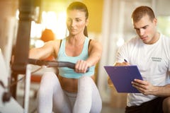 Mulher e instrutor do Gym imagem de stock royalty free Mulher e instrutor do Gym imagem de stock royalty free