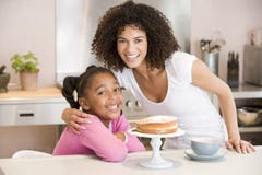 Mulher e rapariga na cozinha com bolo e coff fotografia de stock royalty free Mulher e rapariga na cozinha com bolo e coff fotografia de stock royalty free
