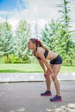 Mulher esgotada jovens durante a atividade dos esportes imagem de stock Mulher esgotada jovens durante a atividade dos esportes imagem de stock
