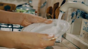 A mulher está lavando um prato com sabão na cozinha Opinião do close-up com movimento lateral da câmera filme A mulher está lavando um prato com sabão na cozinha Opinião do close-up com movimento lateral da câmera filme