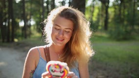 A mulher europeia bonita no vestido faz o selfie e os textos com seu telefone celular na floresta no por do sol, selfie fora, usa filme A mulher europeia bonita no vestido faz o selfie e os textos com seu telefone celular na floresta no por do sol, selfie fora, usa filme