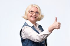 Mulher europeia loura idosa que dá um polegar acima fotos de stock Mulher europeia loura idosa que dá um polegar acima fotos de stock